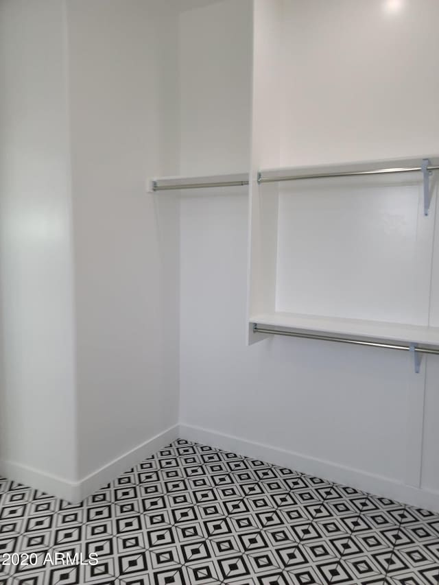 walk in closet with tile floors