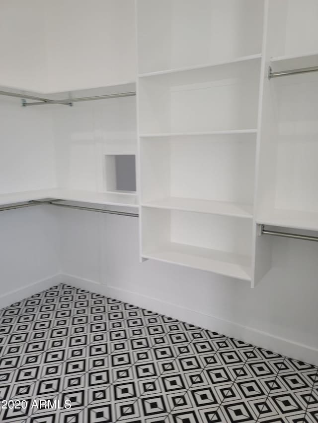 walk in closet with tile flooring