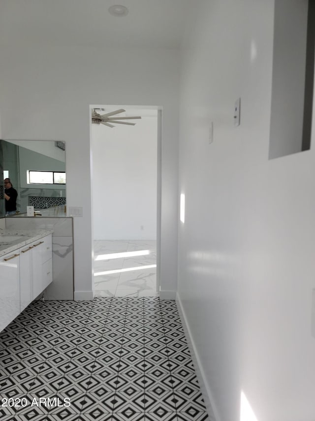 bathroom with ceiling fan, tile floors, vanity, and a washtub