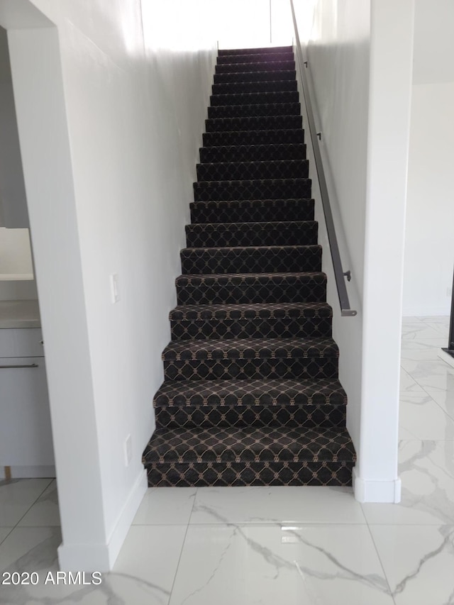 staircase featuring light tile flooring