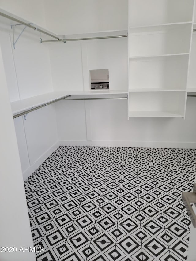 walk in closet featuring light tile floors