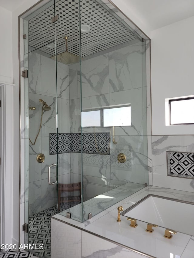 bathroom with plenty of natural light and a shower with shower door