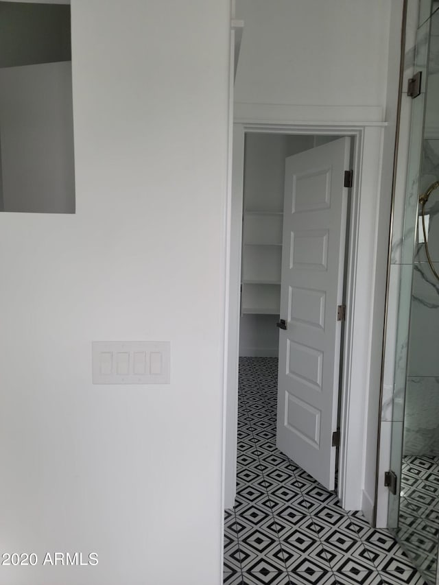 hall with dark tile flooring