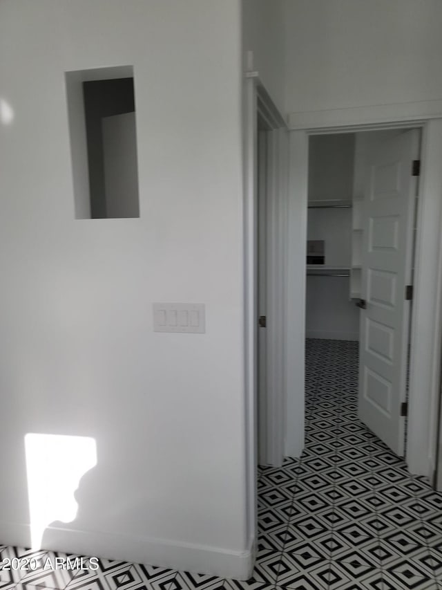 corridor featuring dark tile flooring