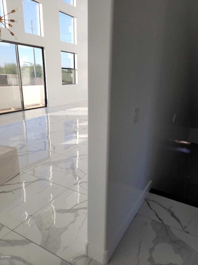 corridor featuring a high ceiling and light tile floors