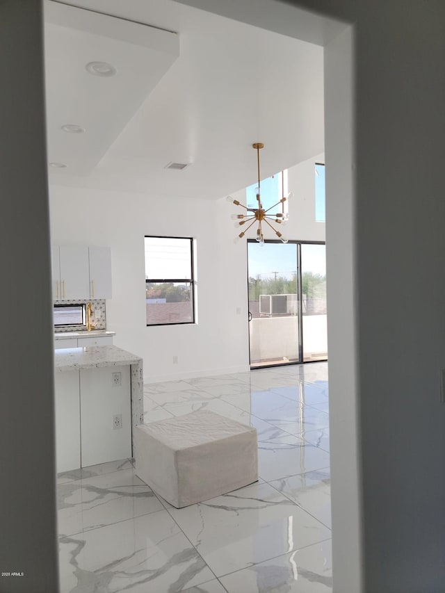 interior space featuring a notable chandelier, tile floors, and tasteful backsplash