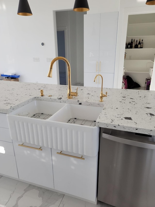 kitchen featuring light stone counters, stainless steel dishwasher, light tile flooring, and white cabinetry