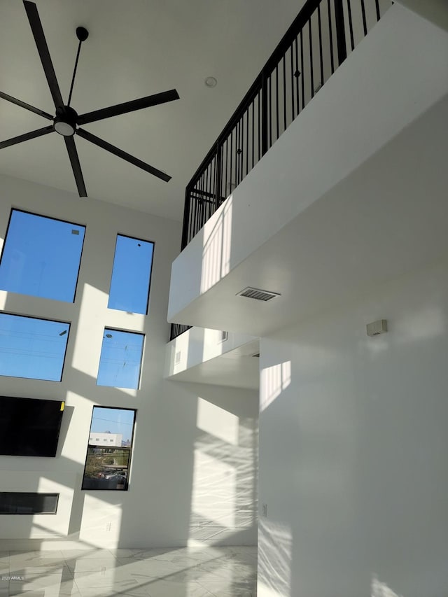 interior space featuring a towering ceiling and ceiling fan