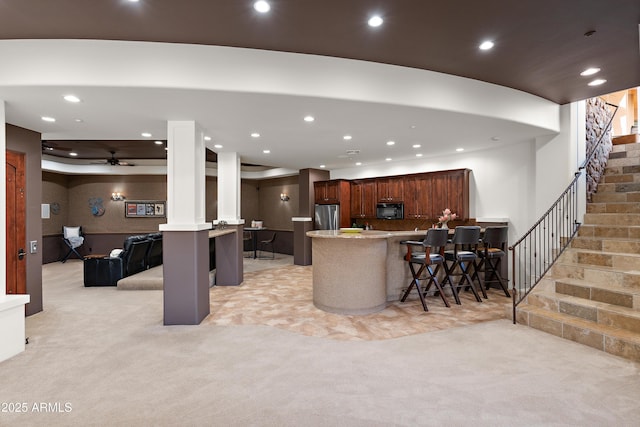 kitchen with light colored carpet, freestanding refrigerator, a peninsula, black microwave, and recessed lighting