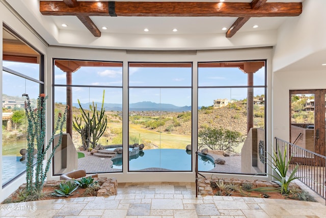 doorway to outside featuring stone tile floors, a mountain view, beam ceiling, and recessed lighting