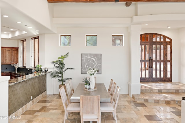 dining area featuring recessed lighting, decorative columns, and stone tile floors