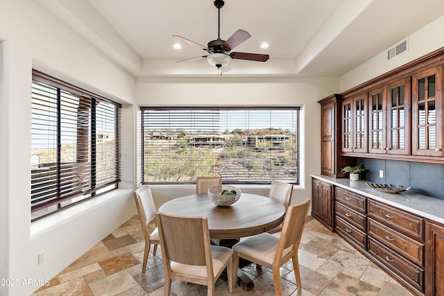 dining space featuring a wealth of natural light, visible vents, and stone tile flooring