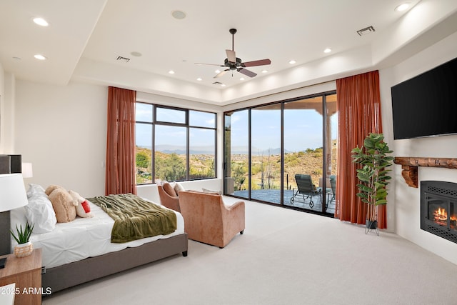 carpeted bedroom featuring access to exterior, recessed lighting, visible vents, and a tray ceiling