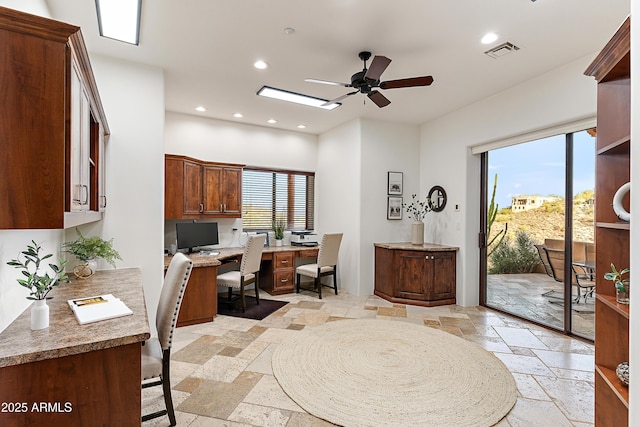 office featuring a ceiling fan, recessed lighting, stone tile flooring, and visible vents