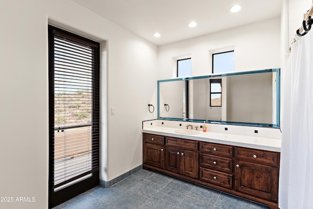 bathroom with tile patterned floors, recessed lighting, baseboards, and vanity