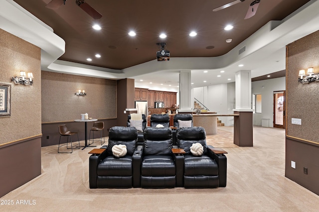 cinema with a tray ceiling, decorative columns, recessed lighting, light carpet, and ceiling fan