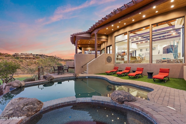 view of swimming pool featuring a pool with connected hot tub and a patio