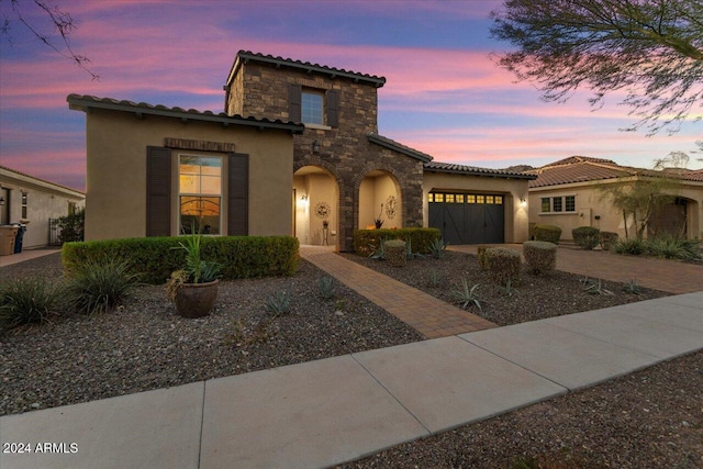 mediterranean / spanish home featuring a garage