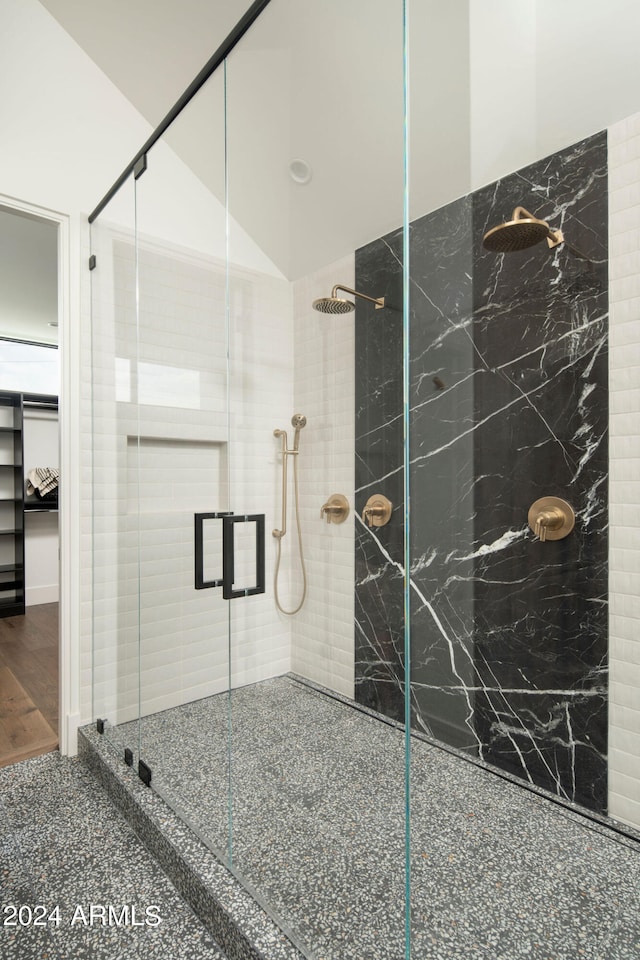 bathroom featuring a tile shower and wood-type flooring