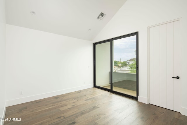 empty room with high vaulted ceiling and dark hardwood / wood-style flooring