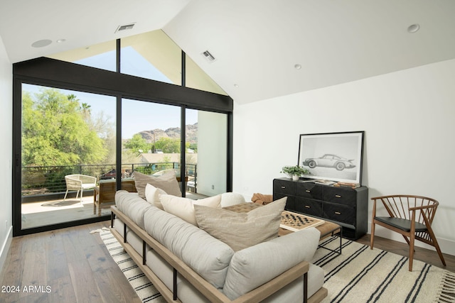 bedroom featuring high vaulted ceiling, wood-type flooring, and access to exterior