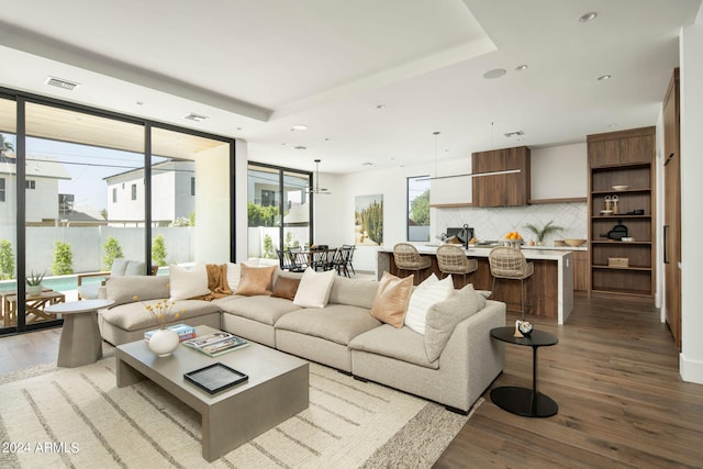 living room featuring wood-type flooring and a tray ceiling