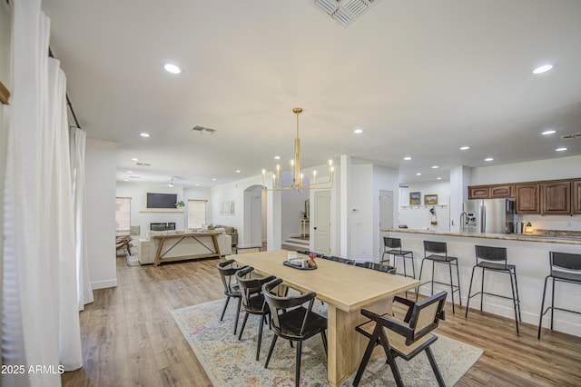 4609 E Ironhorse Rd, Gilbert, AZ 85297 - dining room with light wood-type flooring, recessed lighting, arched walkways, and a chandelier