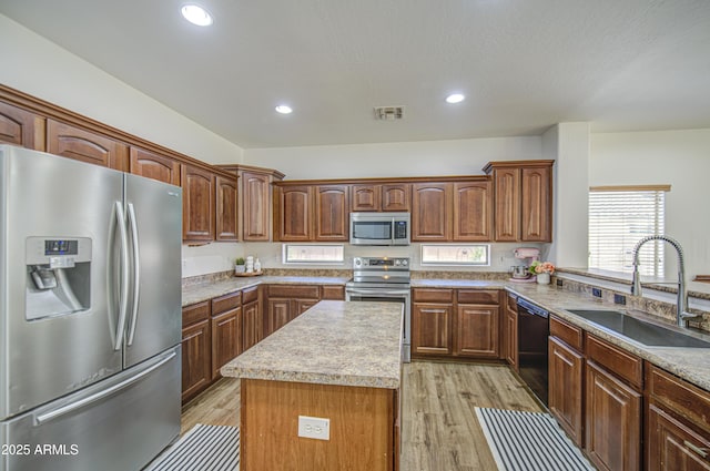 4609 E Ironhorse Rd, Gilbert, AZ 85297 - kitchen featuring stainless steel appliances, a sink, light wood-style floors, a center island, and light countertops