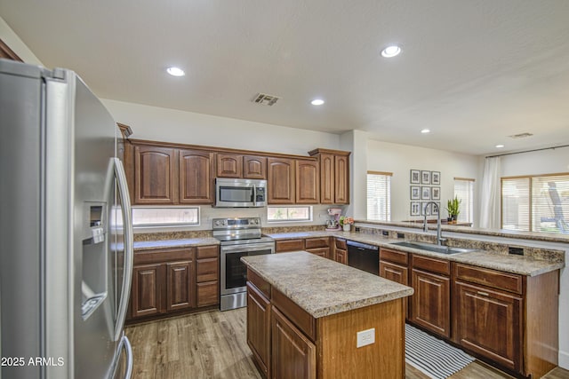 4609 E Ironhorse Rd, Gilbert, AZ 85297 - kitchen with stainless steel appliances, a sink, a peninsula, a kitchen island, and light wood finished floors