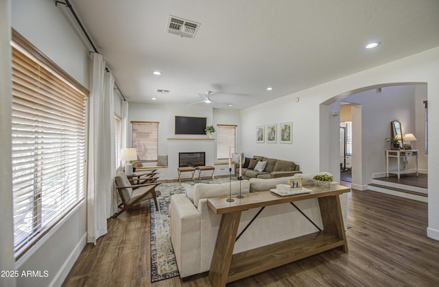 4609 E Ironhorse Rd, Gilbert, AZ 85297 - living area with arched walkways, a ceiling fan, dark wood-style floors, a glass covered fireplace, and recessed lighting