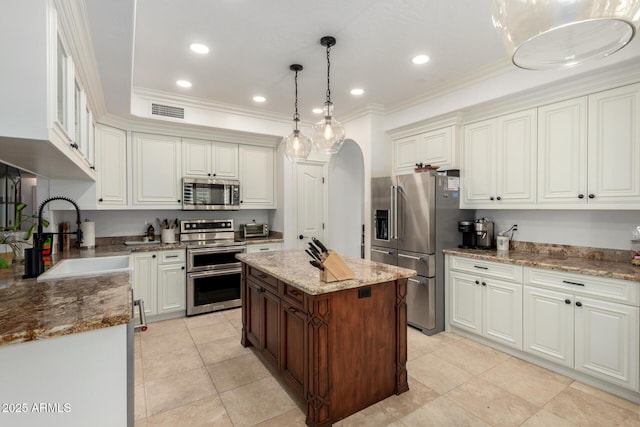 2026 E Cortez Dr, Gilbert, AZ 85234 - kitchen featuring stainless steel appliances, a sink, arched walkways, ornamental molding, and light stone countertops