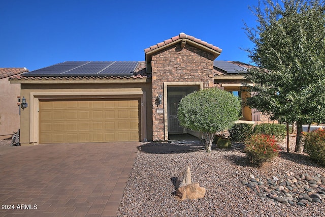 view of front of home featuring solar panels and a garage