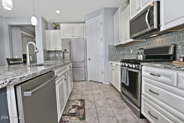 kitchen with backsplash, white cabinetry, and stainless steel appliances