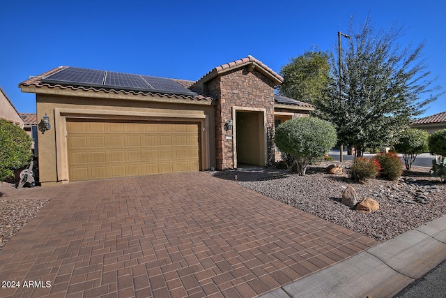 view of front of home featuring solar panels and a garage