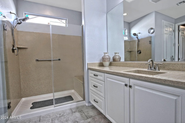 bathroom with tile patterned flooring, vanity, and an enclosed shower