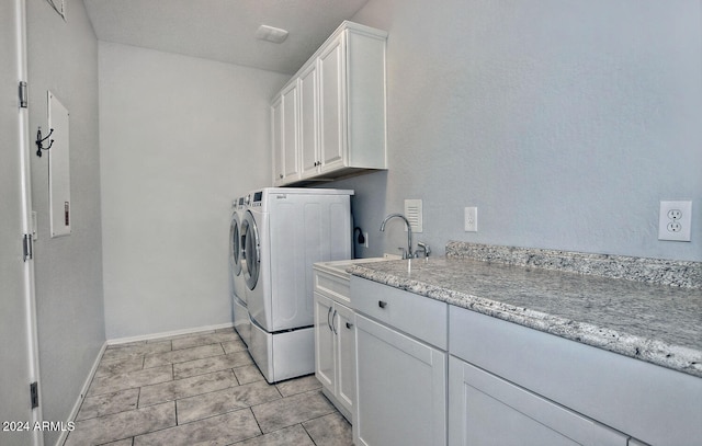 washroom featuring cabinets, light tile patterned flooring, washer and dryer, and sink