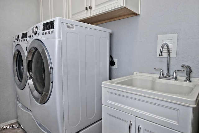 laundry room with cabinets, sink, and washer and dryer