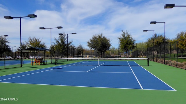 view of tennis court featuring basketball hoop