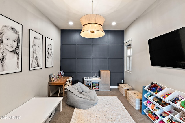 playroom with carpet floors, recessed lighting, and a decorative wall
