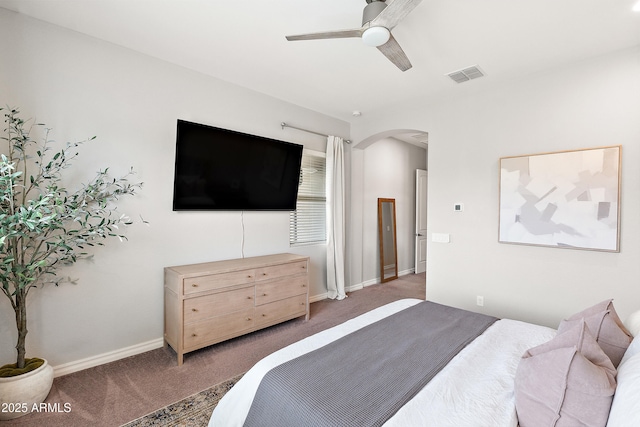 bedroom featuring ceiling fan, visible vents, arched walkways, baseboards, and carpet flooring