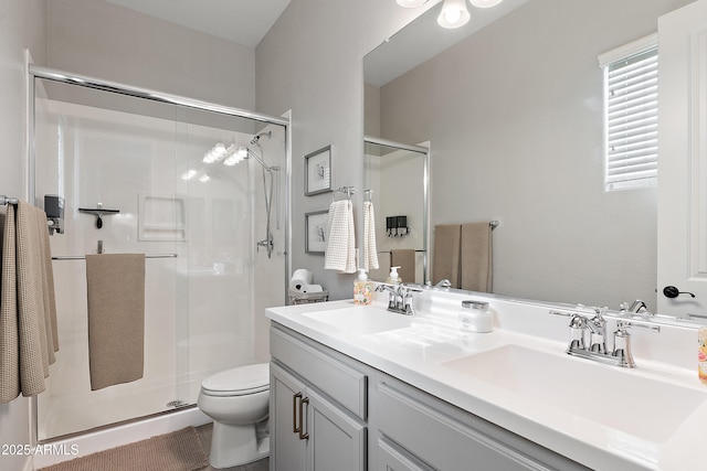 full bathroom featuring a sink, a stall shower, toilet, and double vanity