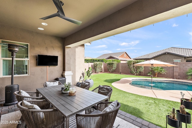exterior space with a fenced in pool, a fenced backyard, and a ceiling fan