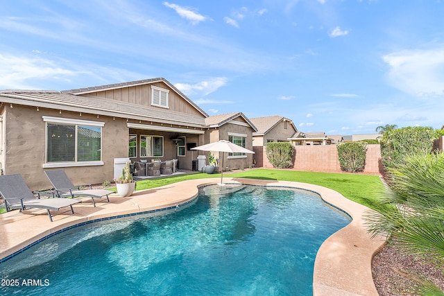 view of swimming pool with fence, a fenced in pool, a lawn, and a patio area