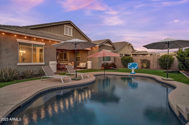 pool at dusk featuring fence, a fenced in pool, and a patio area