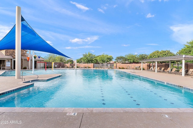 community pool with a patio and fence