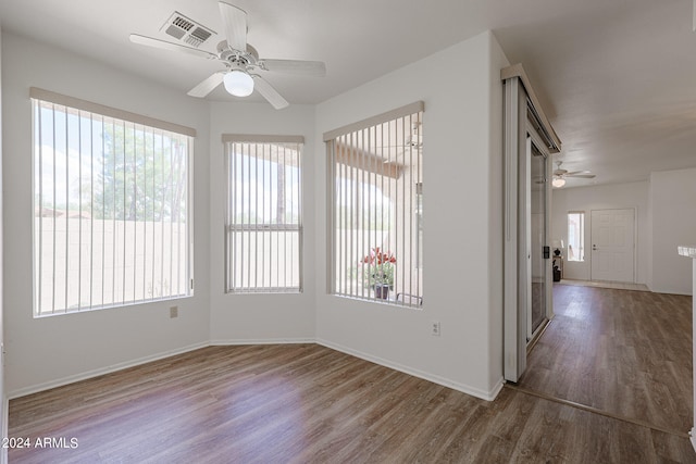 spare room with ceiling fan, plenty of natural light, and hardwood / wood-style floors