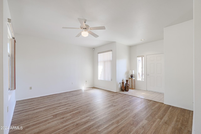 unfurnished living room featuring ceiling fan and light hardwood / wood-style flooring