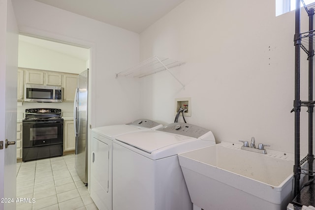 laundry area with washing machine and dryer, light tile patterned flooring, and sink