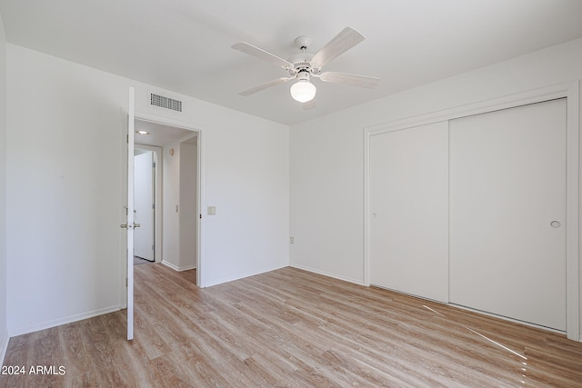 unfurnished bedroom featuring ceiling fan, a closet, and light wood-type flooring