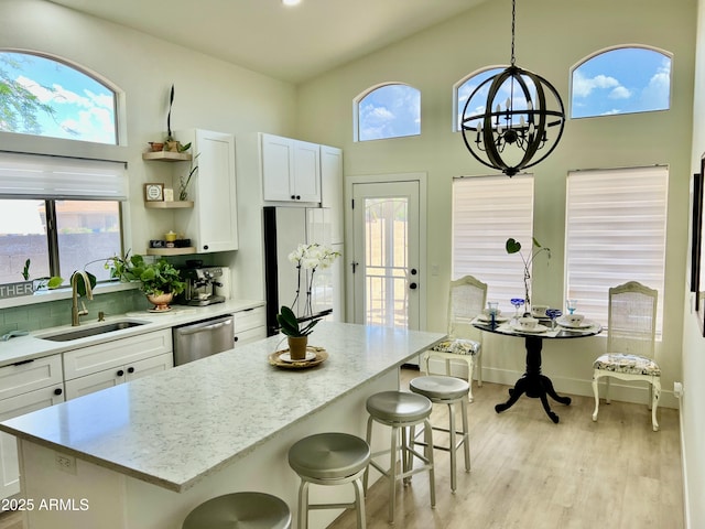 4925 W Bluefield Ave, Glendale, AZ 85308 - kitchen featuring stainless steel dishwasher, open shelves, white cabinets, a breakfast bar, and a towering ceiling